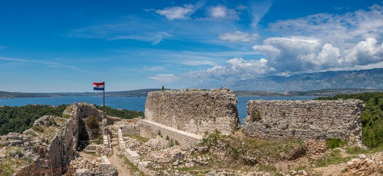 Croatian flag flies above ruins of old Venetian fort above the coastal town of Novigrad in Croatia