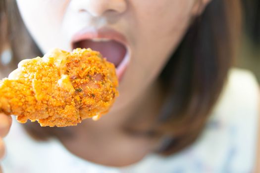 Close up woman eating fried chicken legs, selective focus