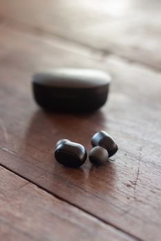 Wireless headphones on wooden background, stock photo