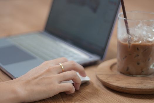 Woman working on computer in coffee shop, stock photo