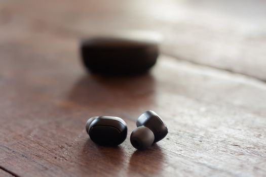 Wireless headphones on wooden background, stock photo