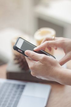 Woman using smart phone in coffee shop, stock photo