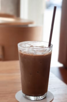 Iced coffee in coffee shop on wooden table, stock photo