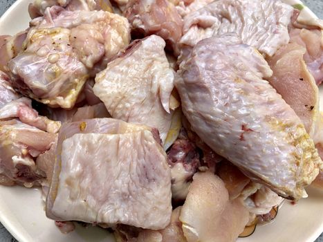 Small pieces of raw chicken meat kept in a plate for cooking