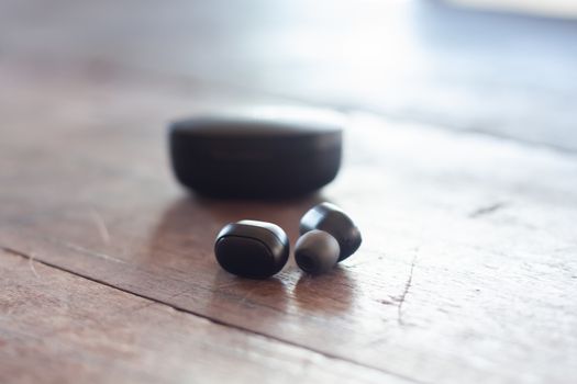 Wireless headphones on wooden background, stock photo