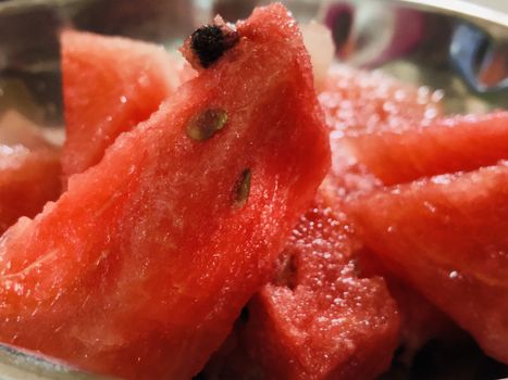 Raw water melons are cut into pieces for serving after lunch