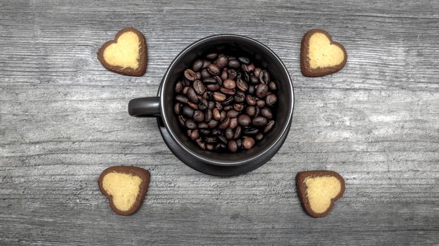 coffee with cookies. Ripe coffee beans in a coffee mug with cookies in the form of hearts