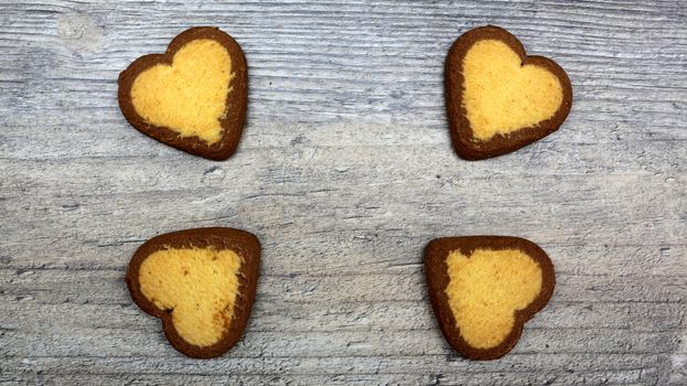 heart-shaped cookies with tea or coffee lie on a wooden table