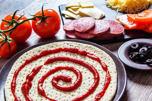 Cooking pizza at home. Ingredients for cooking pizza are on a wooden table.