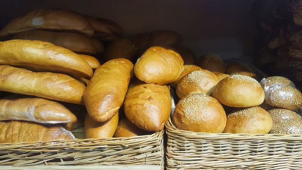 The counter with the bread. Loaves, bread, baguettes and pastries are on the counter in a store or supermarket. Freshly baked bread