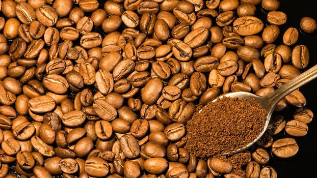 Coffee beans close-up with a spoon of ground coffee on a mirror background.