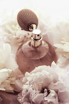 Retro fragrance bottle as luxury perfume product on background of peony flowers, parfum ad and beauty branding design