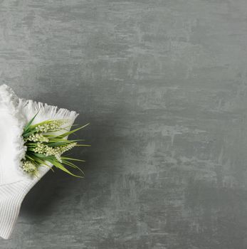 soft towel with a flower in a grey decorative stucco background. top view, isolated