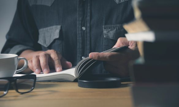 Man reading a book on the table. Education and people concept.