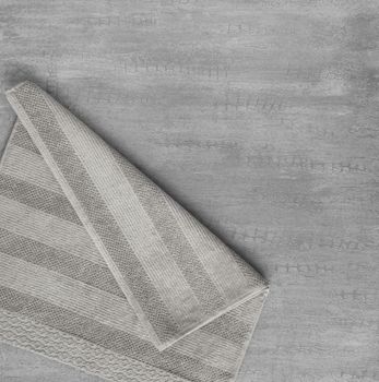 soft towel in a grey decorative stucco background. top view, isolated