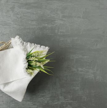 soft towel with a flower in a grey decorative stucco background. top view, isolated