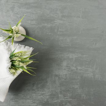 soft towel with a flower in a grey decorative stucco background. top view, isolated