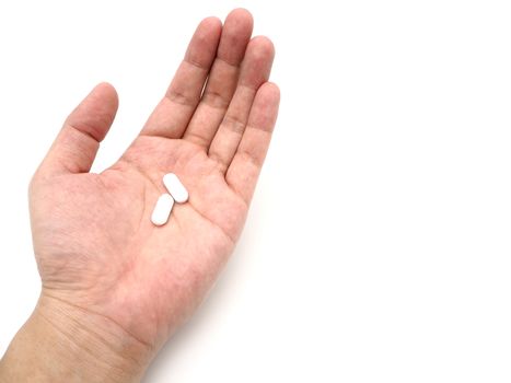 Hand holding a white pills isolated on white background.