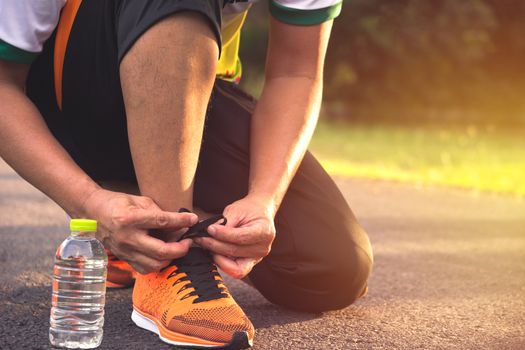 A man preparing and wearing sports shoes for jogging and exercise in the morning.