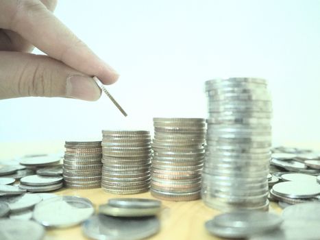 Hand drop a coin with money coin stack growing for business. financial and accounting concept.