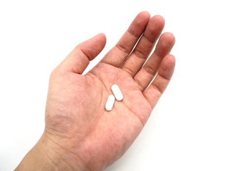 Hand holding a white pills isolated on white background.
