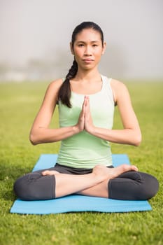 Portrait of focused sporty woman doing the lotus pose in parkland