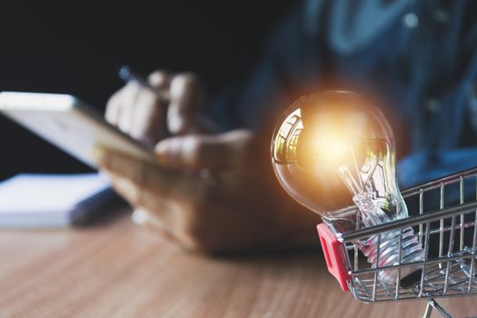 Businessman and light bulb in the shopping cart for accounting and business concept.