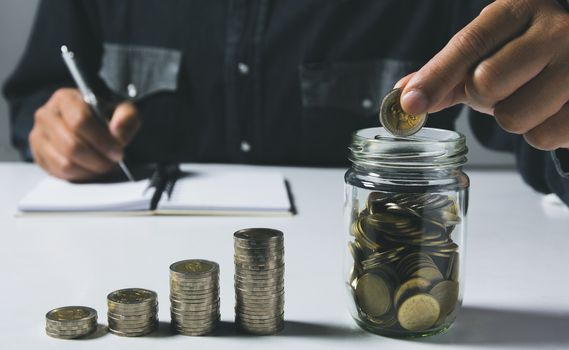 Hand drop a coin with money coin stack growing for business. financial and accounting concept.