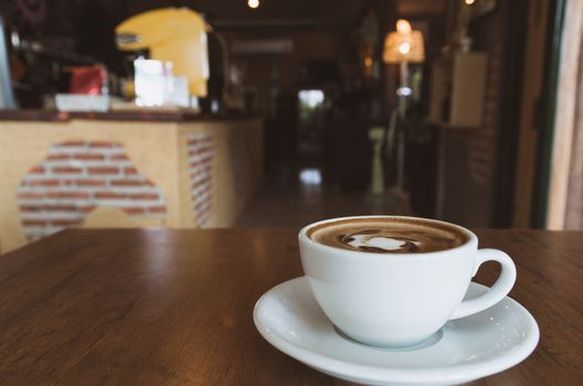A coffee cup on wooden table in coffee shop and copy space.