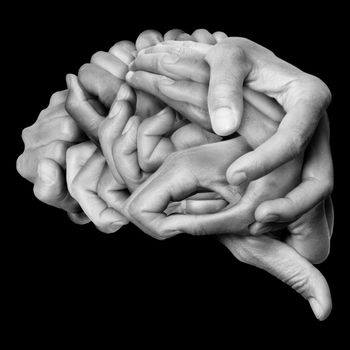 Human brain made with hands, different hands are wrapped together to form a brain. Black background.