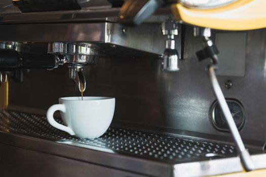 A coffee cup with coffee machine in coffee shop.