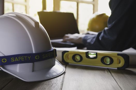 Architect engineer working concept with laptop and construction tools or safety equipment on table.