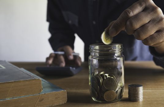 Hand drop a coin with money coin stack growing for business. financial and accounting concept.