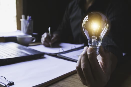 Hand of male holding a light bulb and writing for idea and creative concept.
