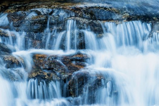 Beautiful veil cascading waterfall, mossy rocks 