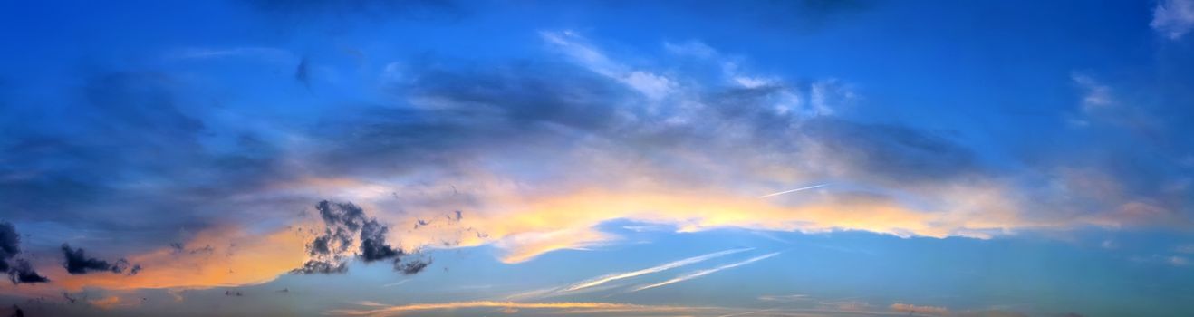 Beautiful high resolution panorama of orange and red sunset clouds in the evening sky.