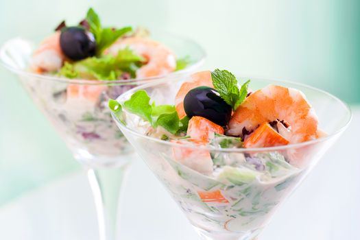 Extreme close up of shrimp and crab cocktail salad served in transparent glasses.