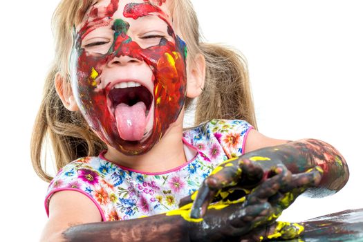 Close up portrait of Little girl messed with color paint. Girl doing funny face sticking out tongue.Isolated on white background.