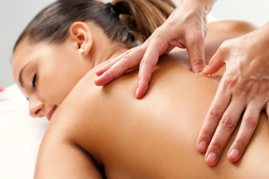 Close up of Therapist doing curative healing massage with thumbs on female back.