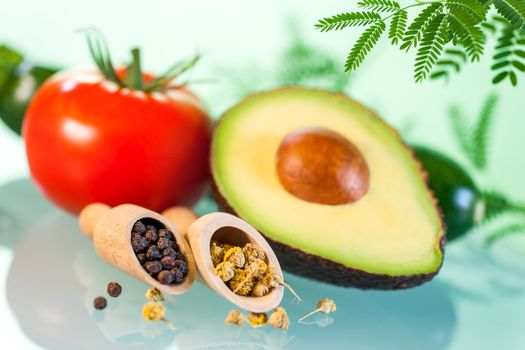 Macro close up Still life of Naturopathic products.Avocado with herbs and seeds against green background.