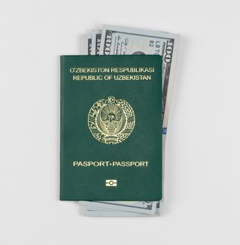 Uzbekistan passport with american dollars on white background, isolated. Top view