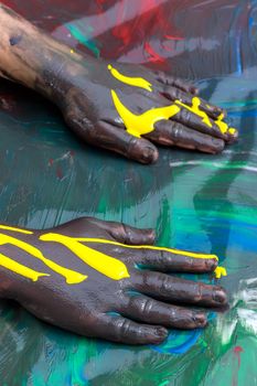 Close up of Infant hands painting and messing with color paint.