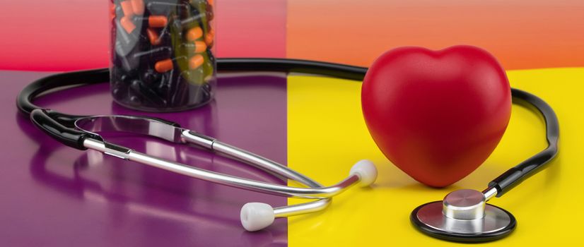 Toy heart and stethoscope on a colored background. Concept healthcare. Cardiology - care of the heart