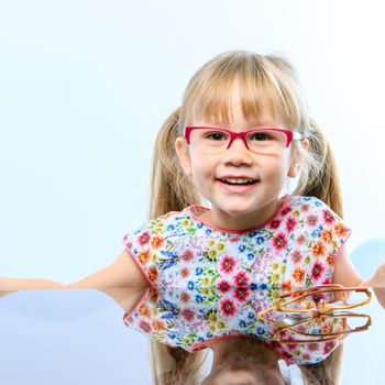 Close up portrait of cute little girl wearing new glasses.