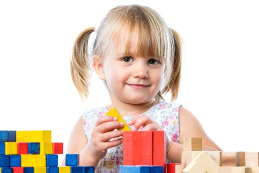 Close up portrait of infant playing building game with wooden blocks at table.Isolated on white background.