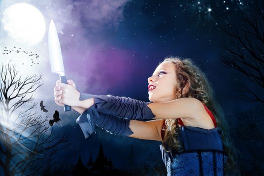 Close up portrait of young female vampire holding big knife. Castle towers and crows flaying in full moon background.