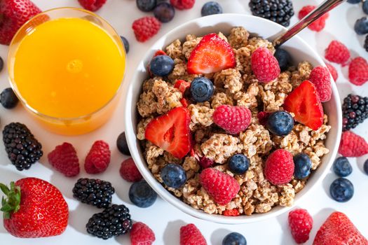 Top view of muesli with red fruits and orange juice.Macro close up of crunchy muesli with red fruits.