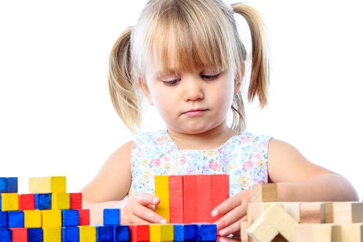 Close up portrait of cute little girl playing with wooden blocks.Isolated on white background.