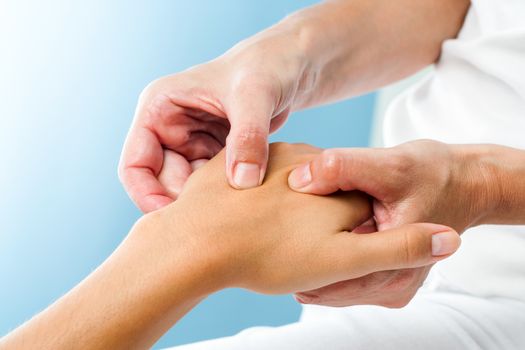 Macro close up of Therapist doing massage on female hand.Osteopath applying pressure on hand.