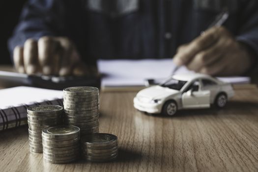 Car insurance and car service. Businessman and toy car for accounting and financial concept.